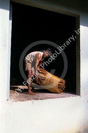 A worker holds a bale of raw latex ready for shipping in Malaysia.