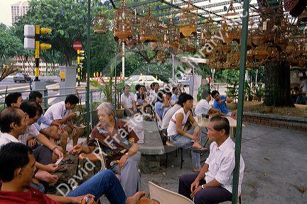Chinese men talking at a Bird Market in Singapore.