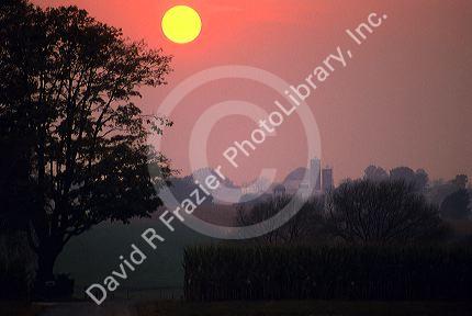 Sun setting in Lancaster County, Pennsylvania with country road and corn field.