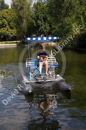 Fifteen year old girl uses a paddlewheel boat on the lagoon in Julia Davis Park, Boise, Idaho.