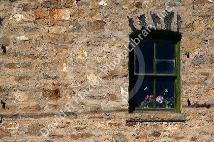 Rock building with window and flowers at Arco, Idaho.