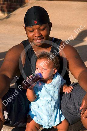 An african american man with his daughter watch a parade in Traer, Iowa.