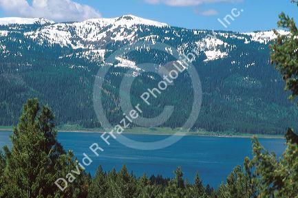 Snow capped peak of West Mountain near Cascade, Idaho with Lake Cascade in the foreground.  Mixed pine are part of the Boise, National Forest.