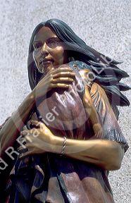 Bronze sculpture of Sacajawea indian woman holding a baby in her arms.  Located in Boise Idaho in front of the Idaho Historical Museum.  Sacajawea lead Lewis and Clark in search of a Northwest Passage.