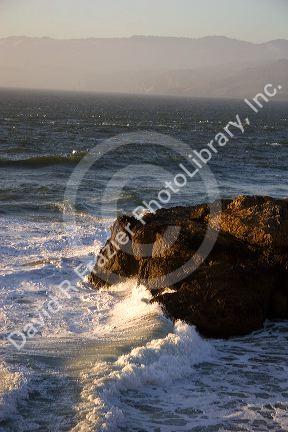Ocean waves crash into rocks on the California Coast near San Francisco, California.