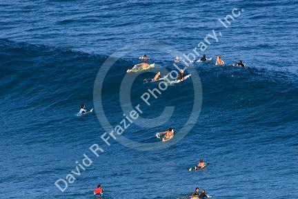 Surfing on waves in the pacific ocean off the island of Maui, Hawaii.