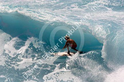 Surfing on waves in the pacific ocean off the island of Maui, Hawaii.