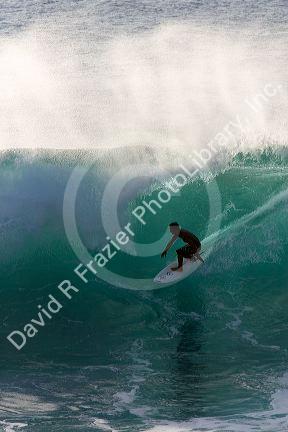 Surfing on waves in the pacific ocean off the island of Maui, Hawaii.