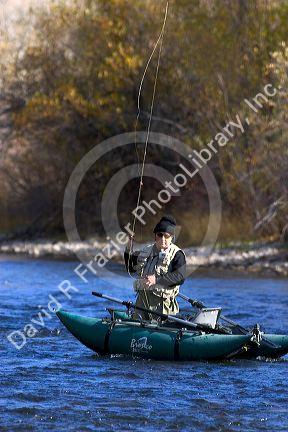 Fly fisherman on the South Fork of the Boise River in Idaho using a small pontoon boat.