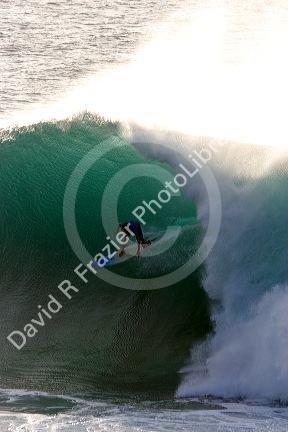 Surfing on waves in the pacific ocean off the island of Maui, Hawaii.