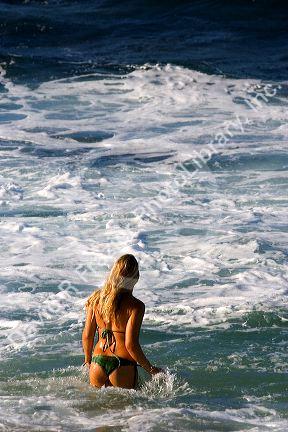 A woman wading in the pacific ocean off the island of Maui, Hawaii.
