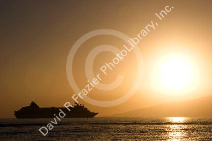A cruise ship at sunset off the island of Maui, Hawaii.