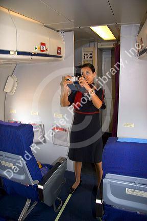 Flight attendant showing how to use a seat belt.