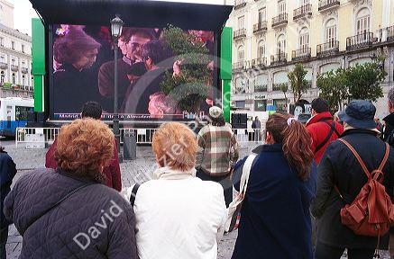 Large screen TV at Puerto del Sol in Madrid shows Queen Sofia mourning at the Memorial service for the Madrid train bombing victims of 3/11/04.