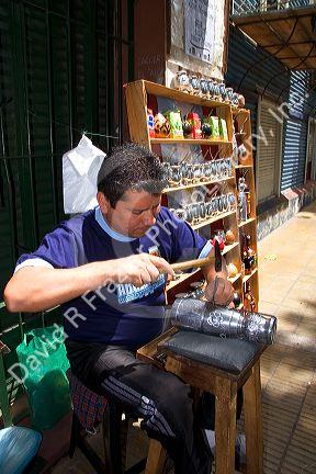 Vendor making and selling silver  cups in the La Boca area of Buenos Aires, Argentina.