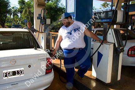 Man pumping gas at a gas station in Argentina.
