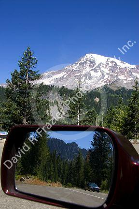 Mt. Rainier in Mt. Rainier National Park, Washington with Cascade Range and highway reflected in automobile mirror.