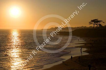 People on the beach at sunset on the pacific ocean at Santa Cruz, California.