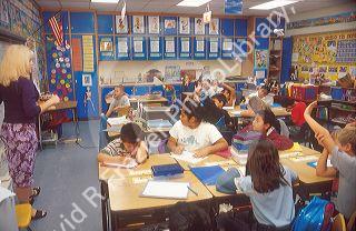 Teacher standing in front of her multi ethnic elementary school class.