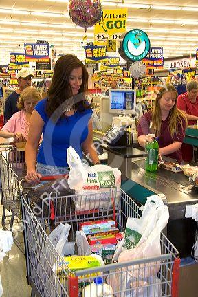 Woman leaving checking out with shopping cart  full of grocery bags at Ray's Market Place in Lima, Ohio.