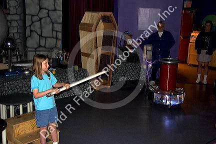 A girl holding a light tube demonstrating a Tesla coil with lightning at the Discovery Center in Little Rock, Arkansas.