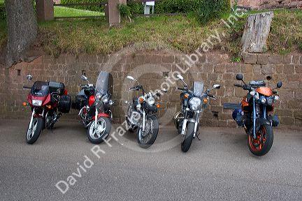 Motorcycles parked along a rock wall in Eastern France.