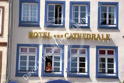 Woman looking out the window of the Cathedral Hotel at Strasbourg, France.