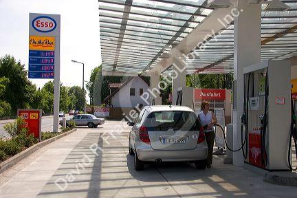 Woman fueling a car at a gas station in Friesing, Germany. MR