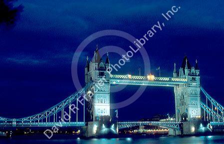 Tower bridge spanning the River Thames in London, England at night.