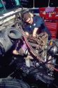 A male truck mechanic working on a diesel engine.
