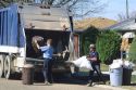 Garbage collectors haul trash from garbage cans.