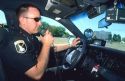 Idaho State Policeman talking on his radio in a police car.