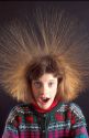 Girl with hair standing on end do to static electricity.