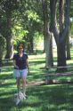 Woman walking her dog in a park.