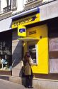 Woman using an atm machine at French Post Office.