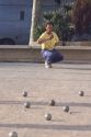 Man playing bocci ball in France.