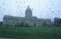 Rain drops on a window with the Kentucky state capitol building in the background.