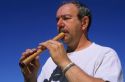 A man plays a soprano recorder.