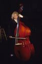 A girl plays an upright bass with a bow.