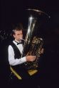 A teen playing an upright tuba.