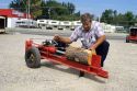 A man uses a gas powered hydrolic log splitter.