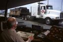Long haul trucks line up a weigh station.