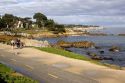 People jogging along the rocky shore in Monterey, California.