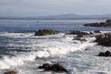 Waves crash along the rocky shore in Monterey, California.