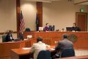Court room scene with  in Boise, Idaho.  Criminal defendant  and lawyer sit with backs to camera.