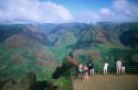 Tourists stand on a platform looking out over Waimea Canyon on the island of Kauai, Hawaii.