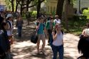 Students walking and using cell phones on the campus of University of Texas in Austin.