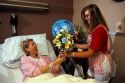 Volunteer candystriper delivers flowers to a hospital patient.