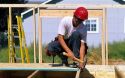 Construction worker installing the tongue and groove sub-floor for a new home.