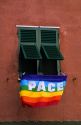 A peace flag hangs from the window of an apartment in Italy.
